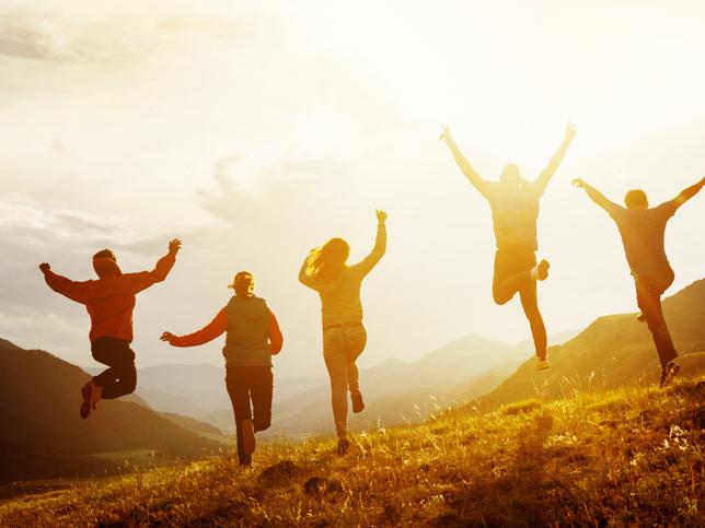 Group of people jumping on a hill