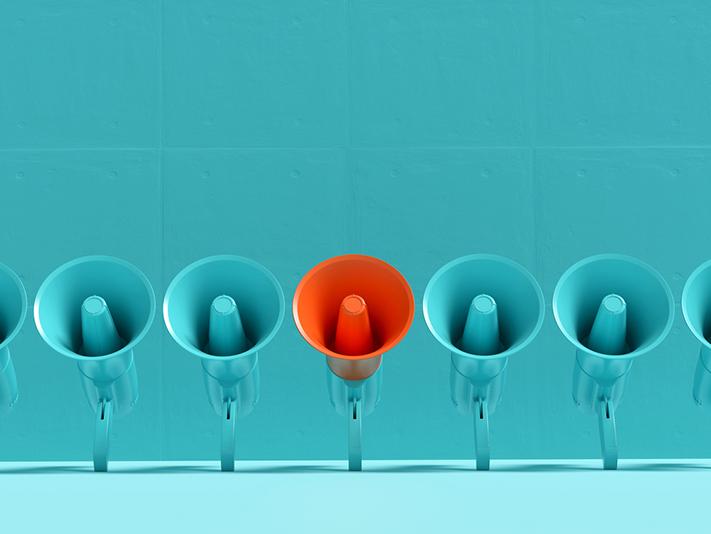 One red megaphone in line of blue, clear communication concept