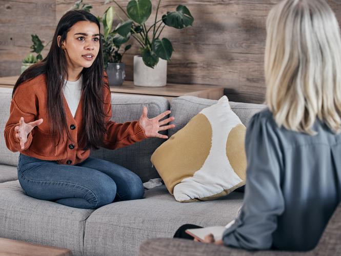 A young woman talks to a therapist earnestly