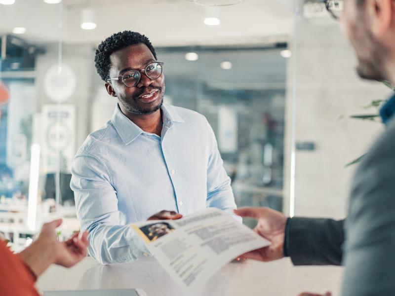 Man hands resume to employer