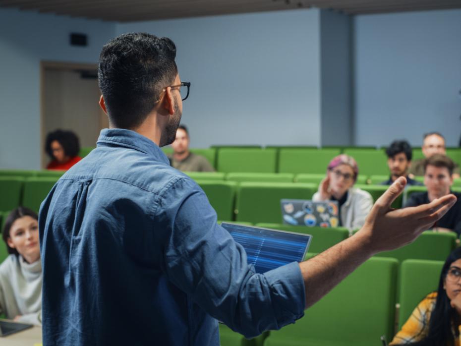 A lecturer at the front of class presenting to students 