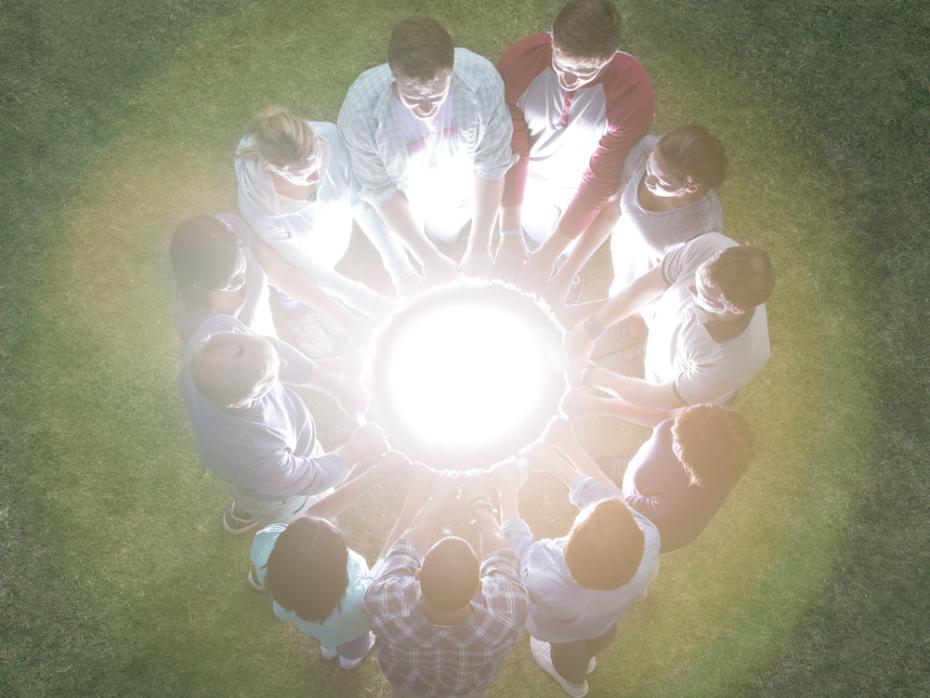 Students holding hands around a glowing orb