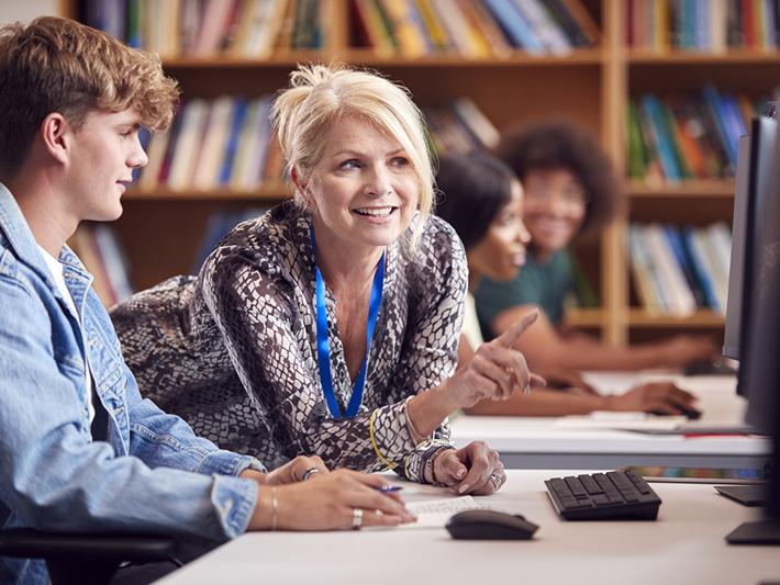 Female college professor helping male student