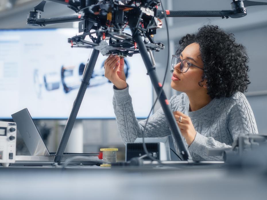 A Black woman engineer building a robot
