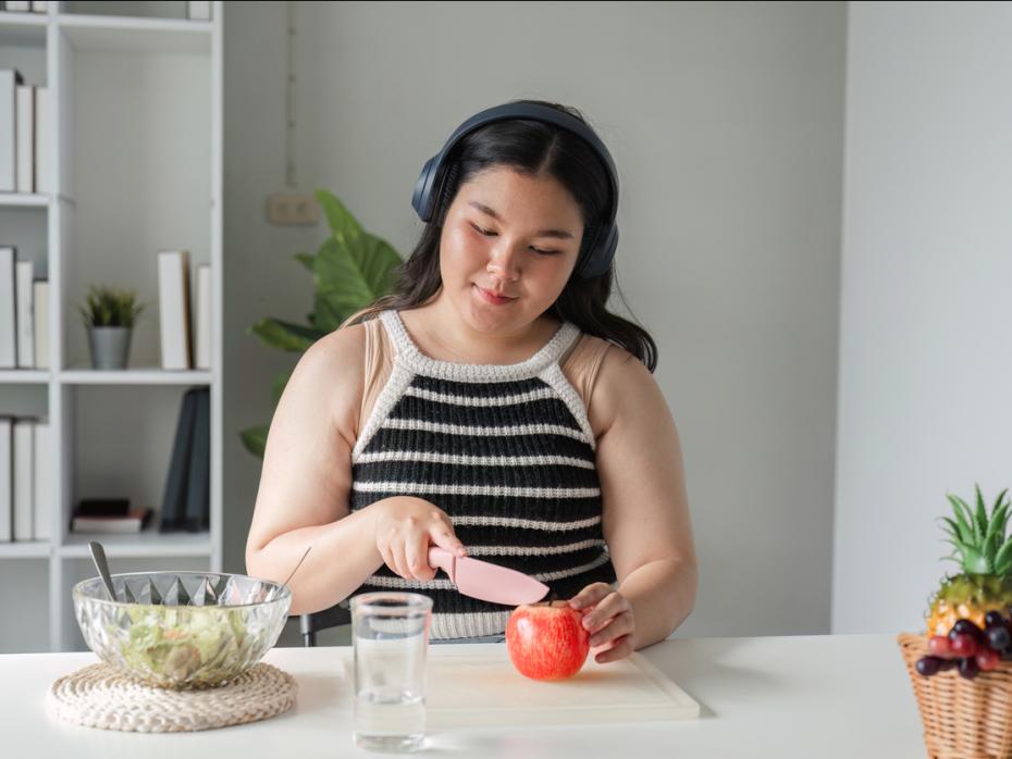 Student with headphones preparing food