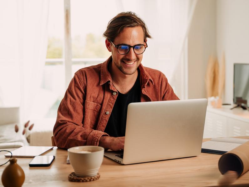 Male student studying at laptop