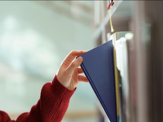 A library book being removed from a shelf