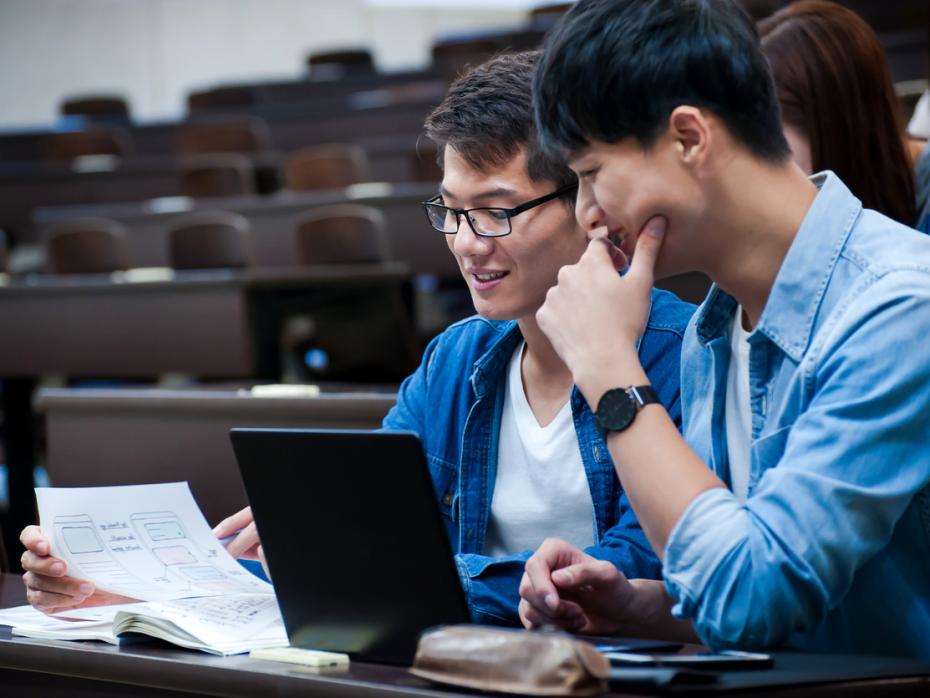 Two language students reading a physical document