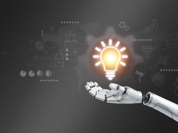 A robot hand holds out a glowing lightbulb