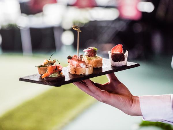 Bite-sized canapes are presented on a slate