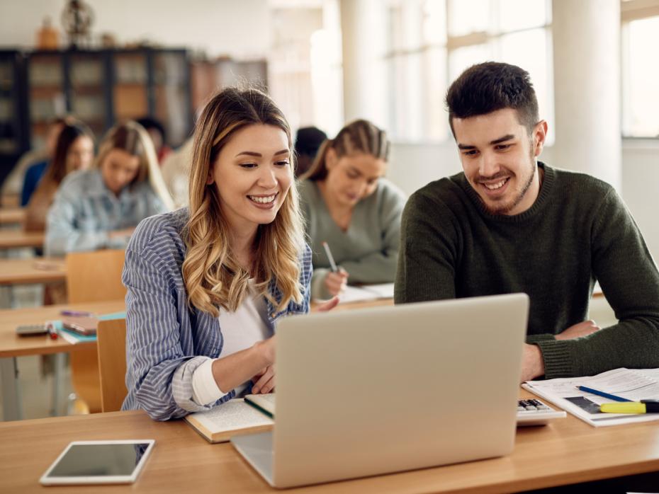 Two students working on a laptop together