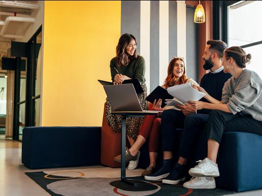Young entrepreneurs chat happily in a breakout space
