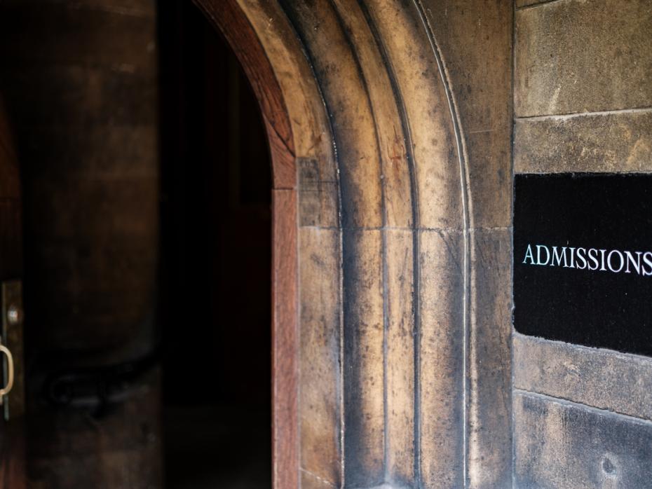 A doorway with an "admissions" sign next to it