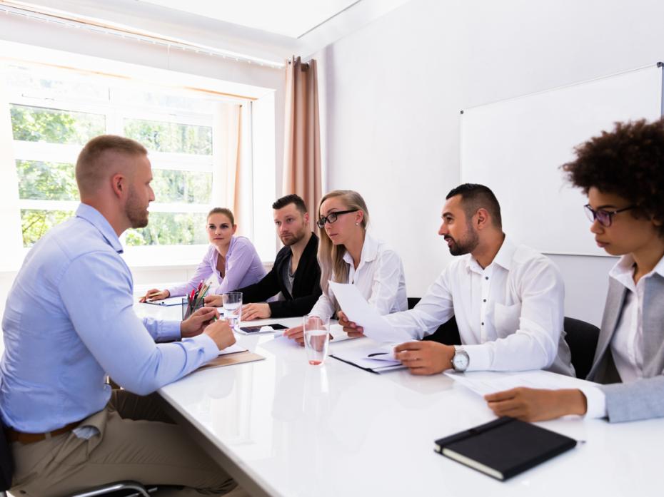 A hiring panel interviewing a candidate at a table