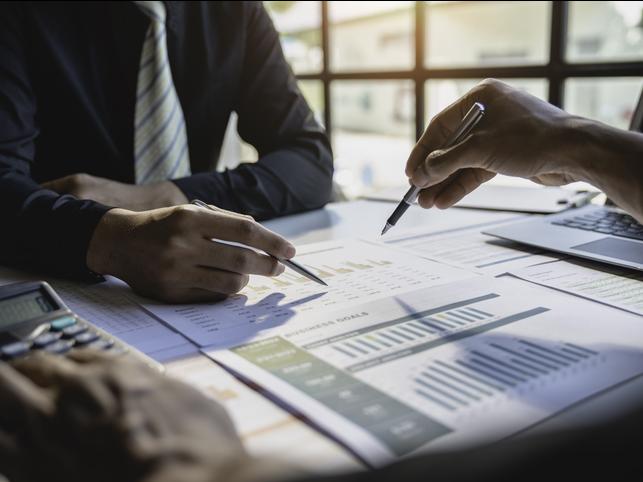 Academics sit round a table, analysing documents