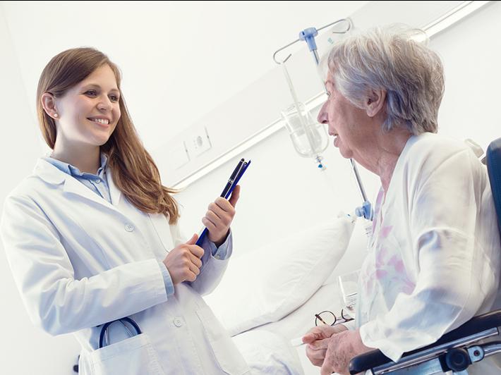 Young female medical researcher with elderly female patient