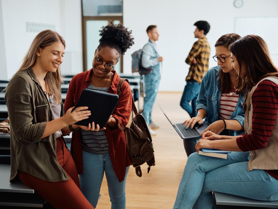 A group of students discussing something on an iPad