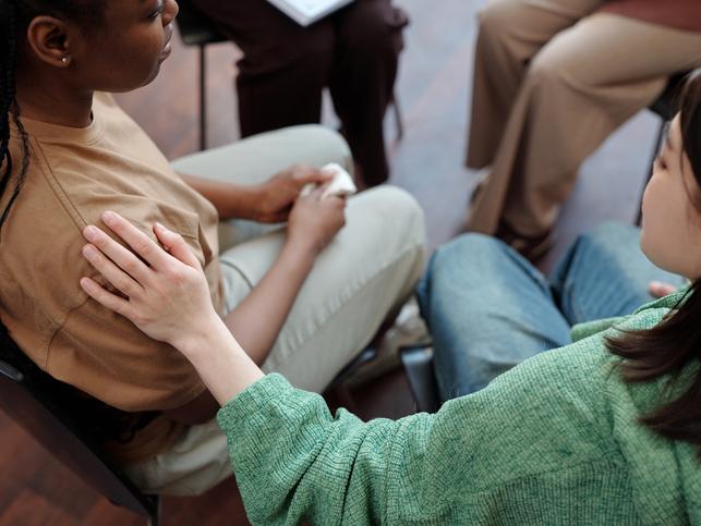 One student comforts another with a hand on the shoulder