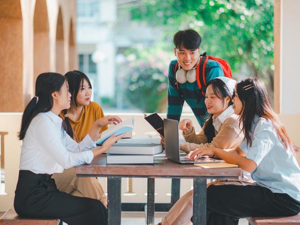 Students discuss their work round a table