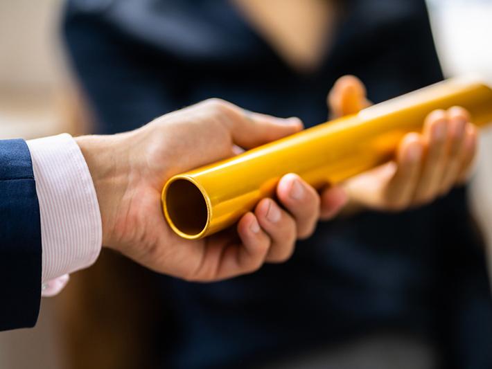 Buinessmen passing a gold baton