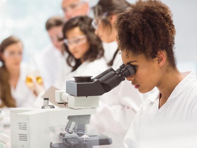 A student uses a microscope in a lab