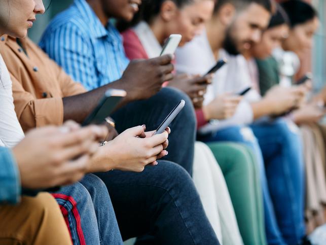 A row of people using smartphones