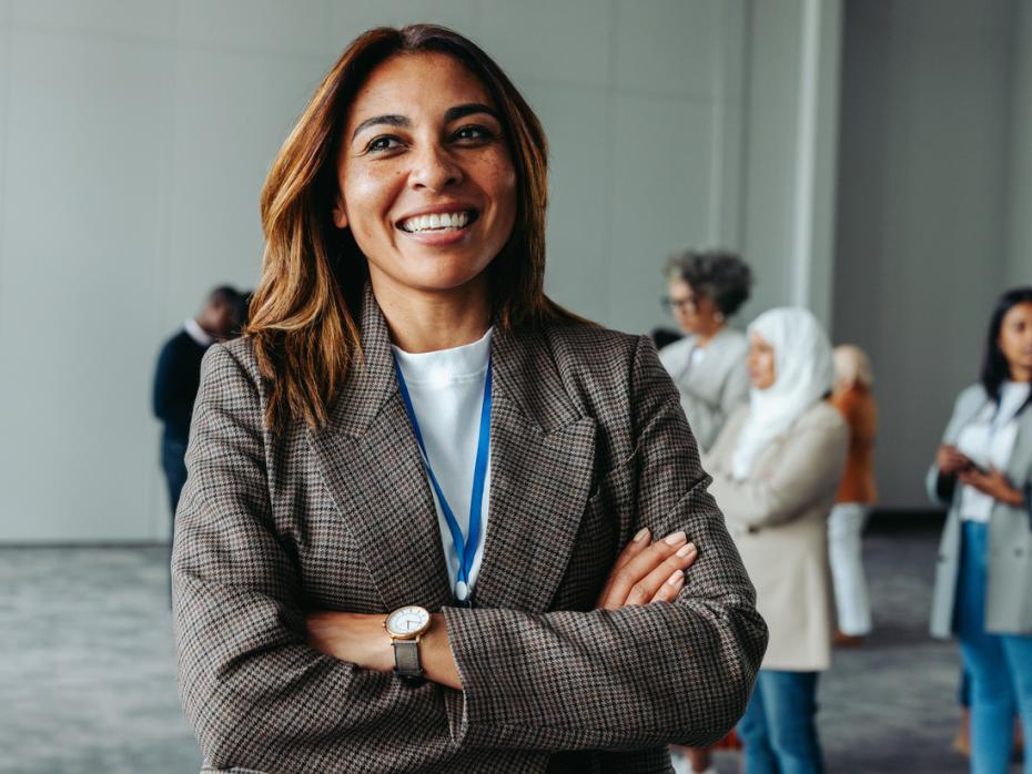 A woman in professional attire smiling to canera