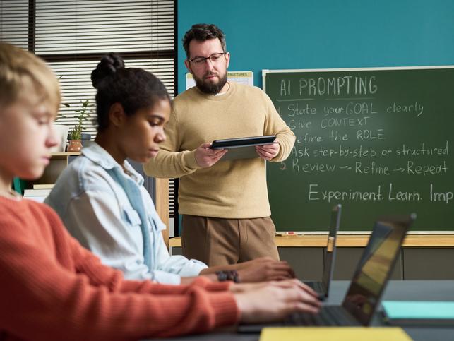 A teacher works with students on GenAI literacy