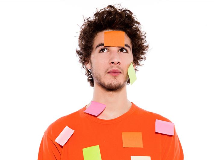 Young man covered in sticky labels