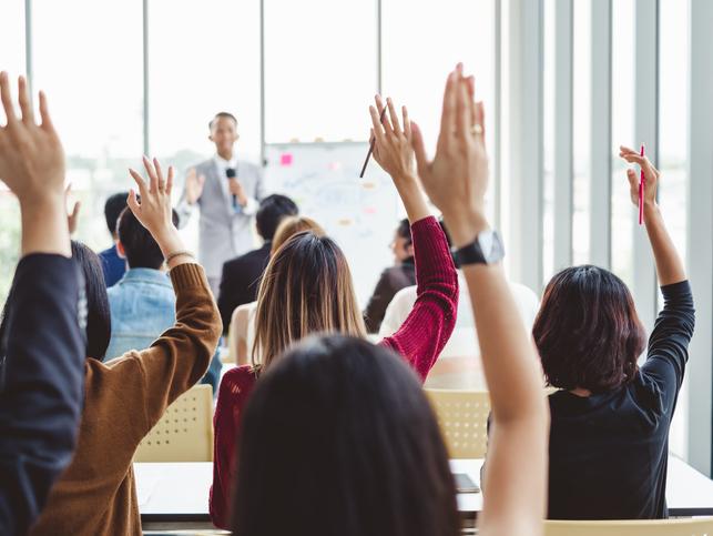 Participants in a seminar raise their hands