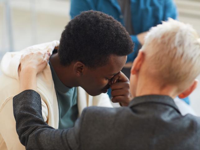 An educator comforts a student