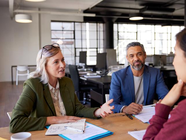 Office workers discuss around a meeting table