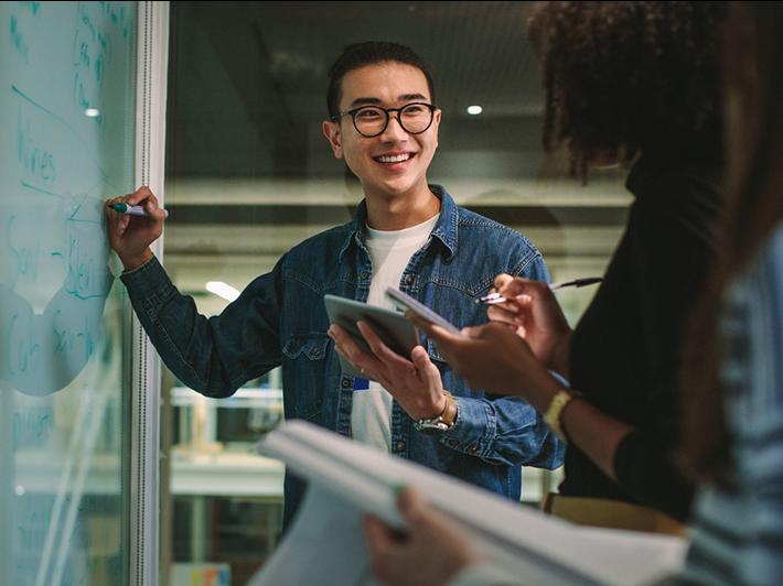 Male Asian teacher at whiteboard