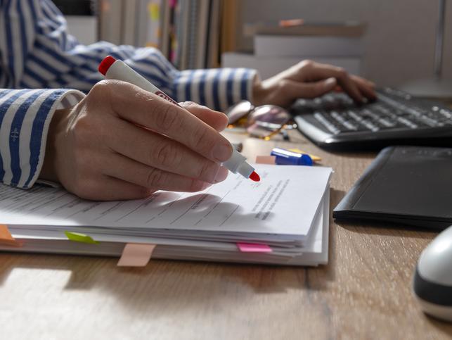A reviewer wields a red pen