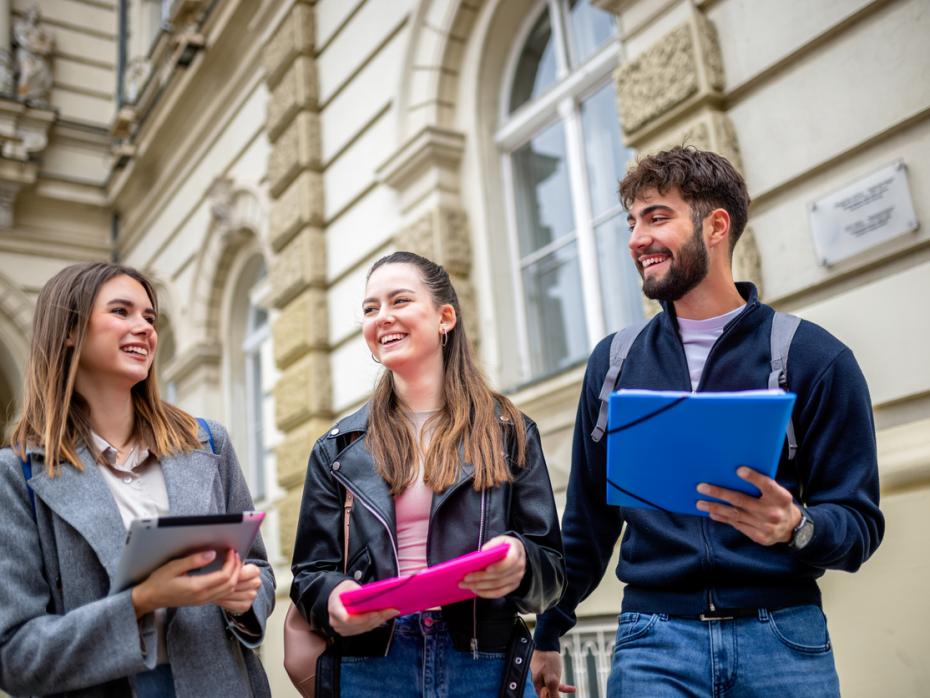 Students smiling outside a university building