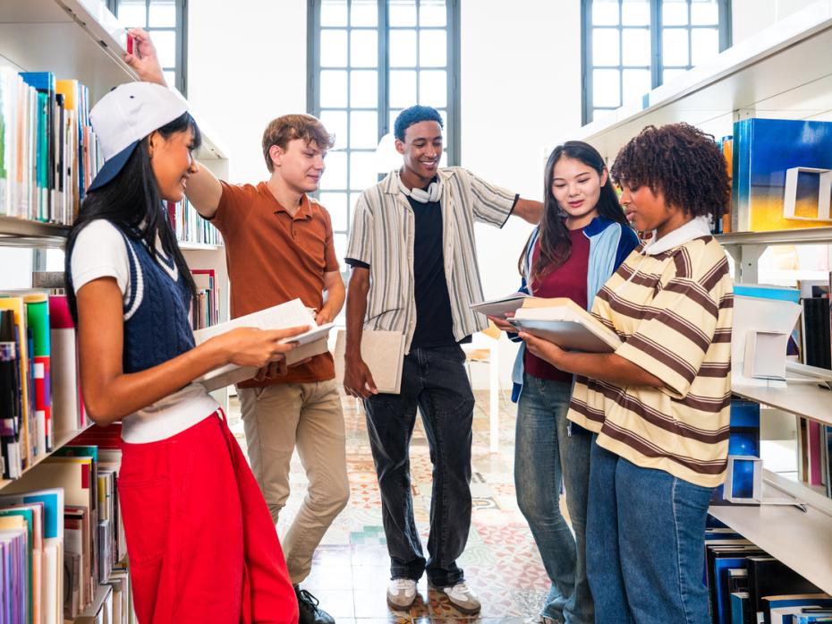Students huddling between aisles in a library