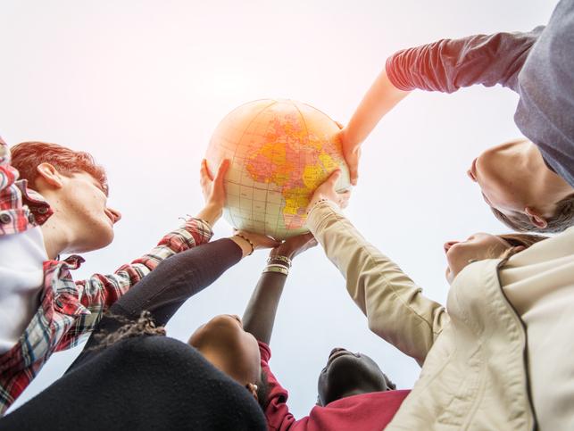 Students hold up an inflatable globe