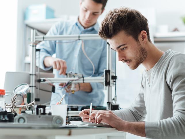 Two researchers make notes while working