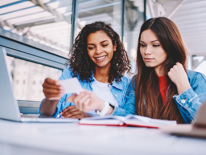 Two female students looking at a flash card