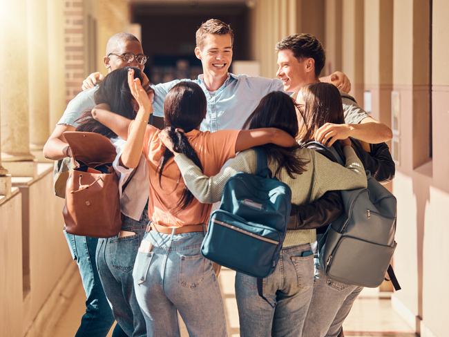 A group of students hug on campus