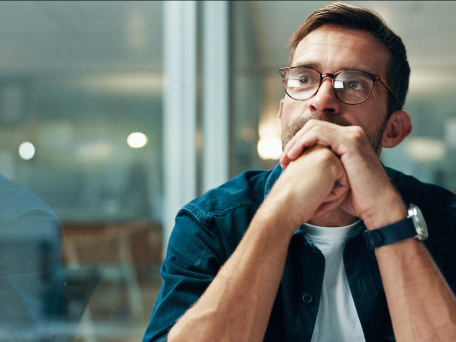 A man sitting at his desk staring into space 