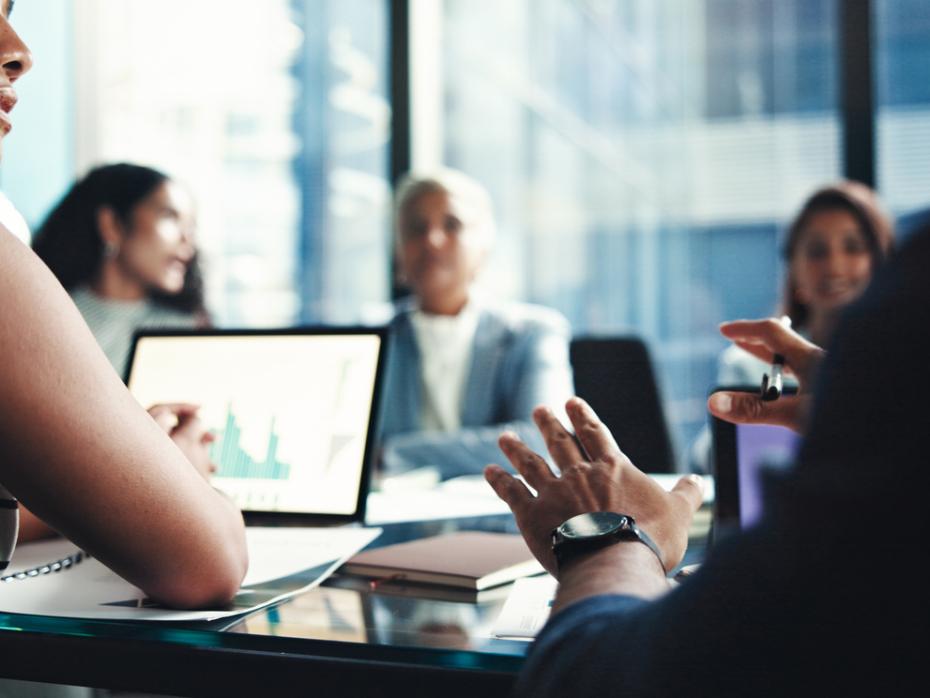 Students in a boardroom working on a company project