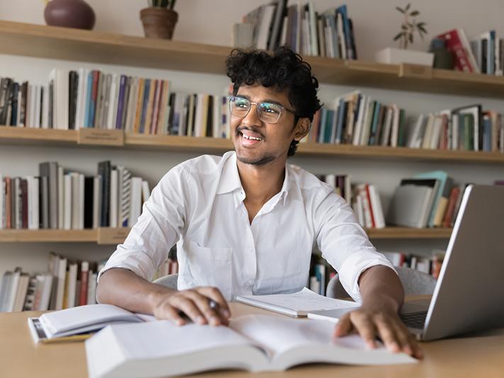 Male South Asian student in university library