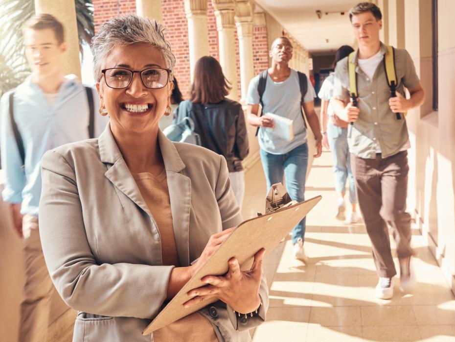 A smiling university professor in a campus hallway