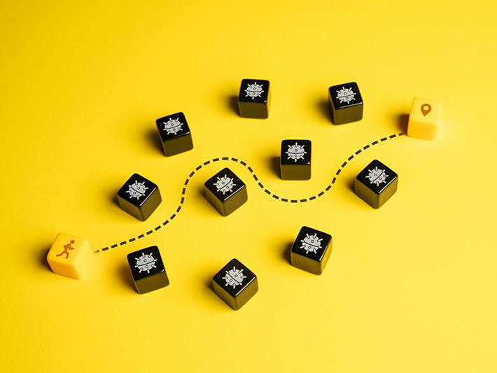 Blocks showing man making path between bombs to idea