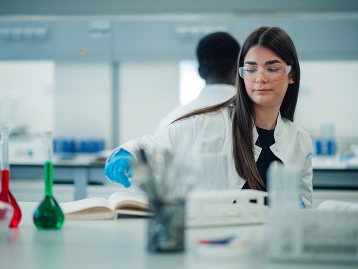 Young female student wearing safety glasses in an organic chemistry lab
