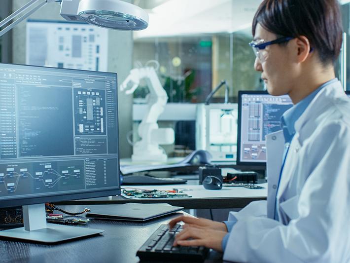 Asian scientist working at computer