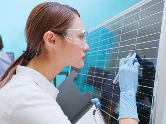 A researcher inspects solar panels in a lab