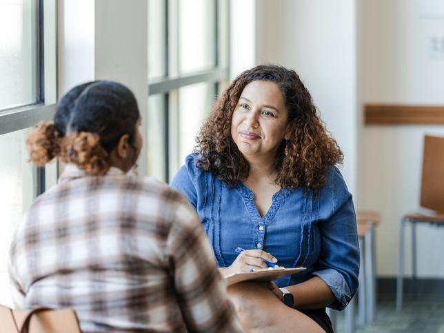 A psychology student providing counselling to a patient in a clinic