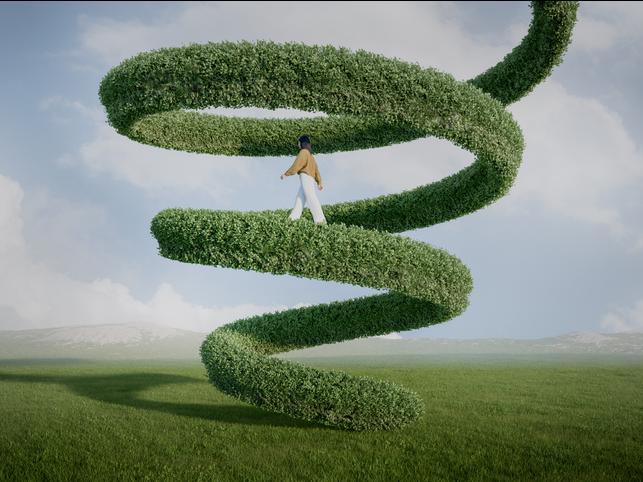 A woman walking up a leafy green structure extending up into the sky